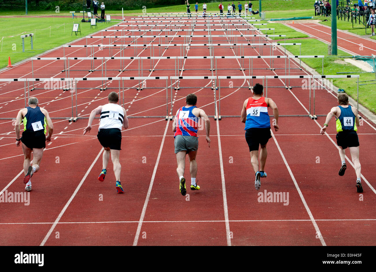 Athletics, runners in men`s 110m hurdles race at club level, UK Stock